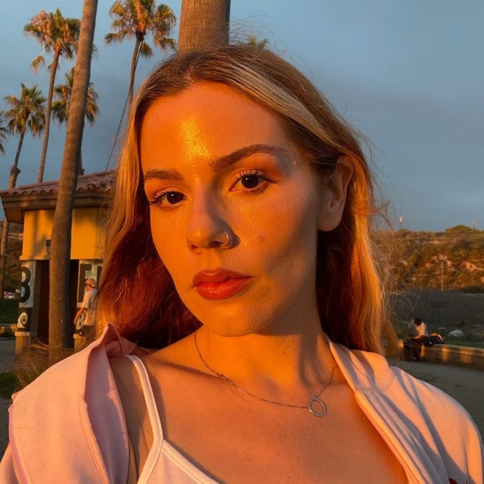 Young woman posing outdoors at sunset, a woke social media user featured in decolonized Christmas discussion.