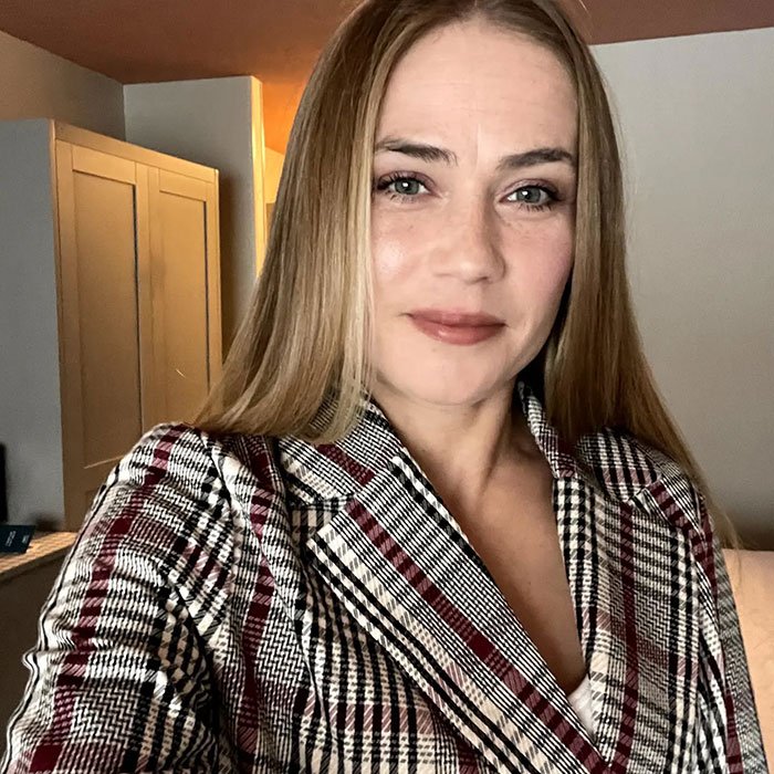 Cinnabon worker in plaid jacket posing indoors, linked to viral racist tirade and revealed criminal past.