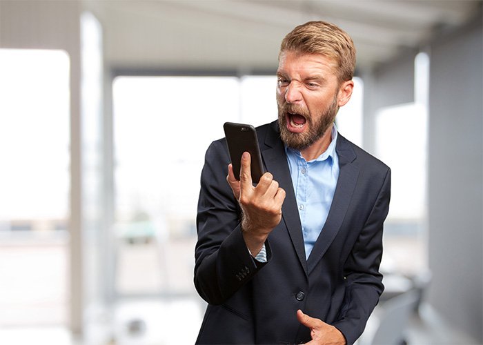 Angry young man in a suit yelling at his phone representing male Karen concept from Gen Z perspective.
