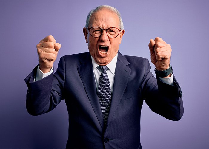 Angry older man in suit expressing frustration, representing the male Karen stereotype known by Gen Z.