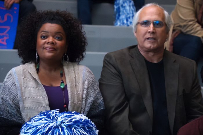 Two actors from Community sitting in bleachers, relating to Chevy Chase's N-Word scandal and new documentary.