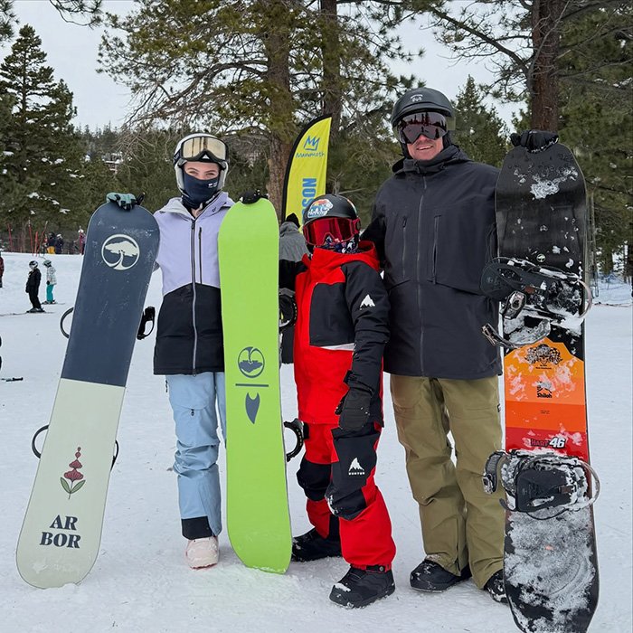 Three people holding snowboards outdoors in winter, related to Pink breaks silence after spending New Year’s Eve alone in hospital.