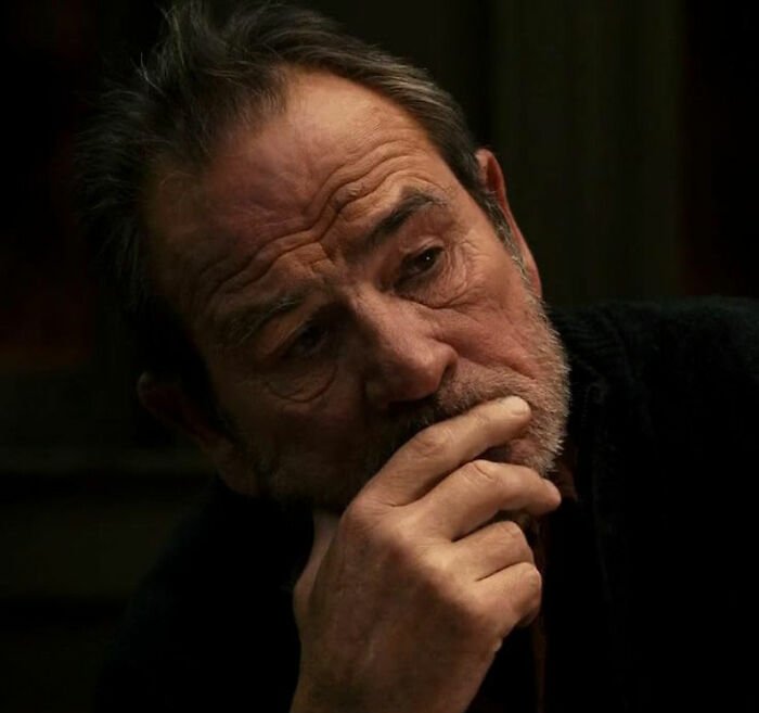 Tommy Lee Jones in a dark setting, looking pensive with hand on chin, related to daughter Victoria story.