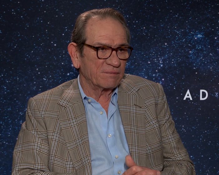 Tommy Lee Jones wearing glasses and a checkered blazer during an interview about Victoria's passing mystery.