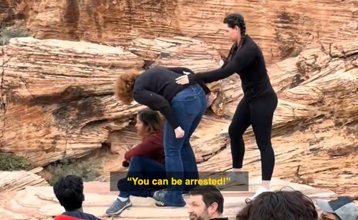 Woman blocking tourist’s shot at Red Rock Canyon during viral first Karen of 2026 incident outdoors on rocky terrain.