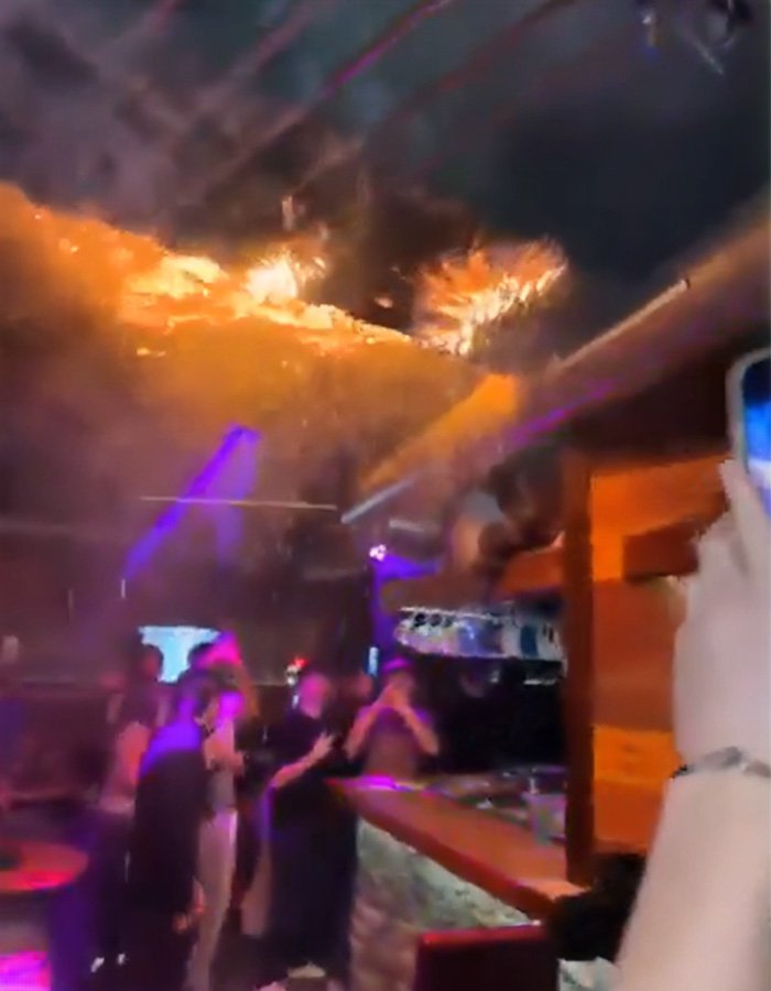 Interior view of a Swiss ski bar with a ceiling fire spreading, showing possible negligence in the lethal fire incident.