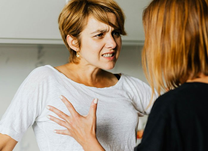 Woman fed up with coworker preaching body positivity while skinny-shaming during heated conversation indoors