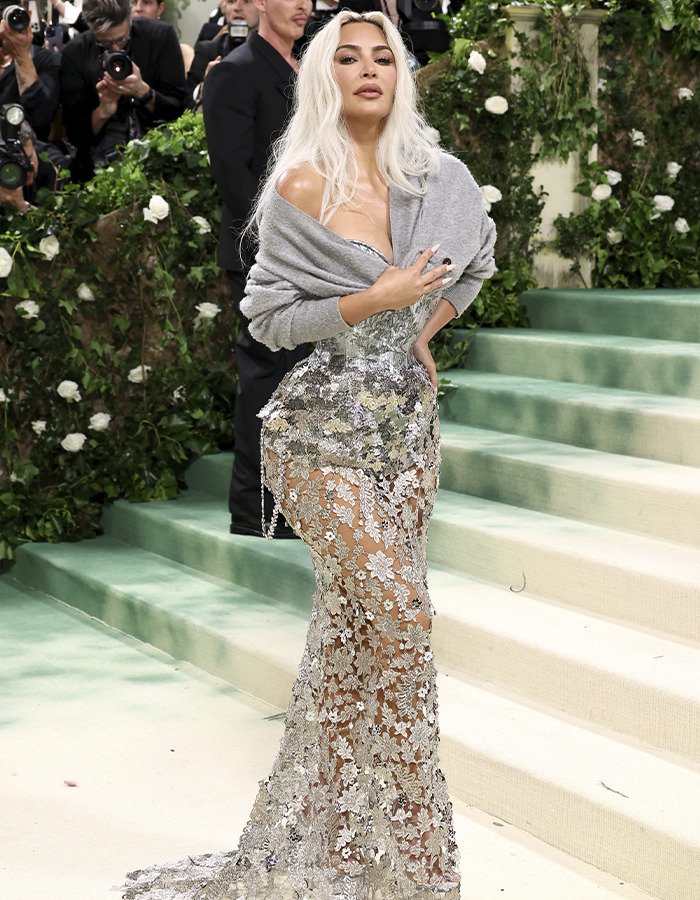 Woman wearing a sheer floral gown at an event, highlighting trends in donated lifeless bodies for BBLs and breast implants.