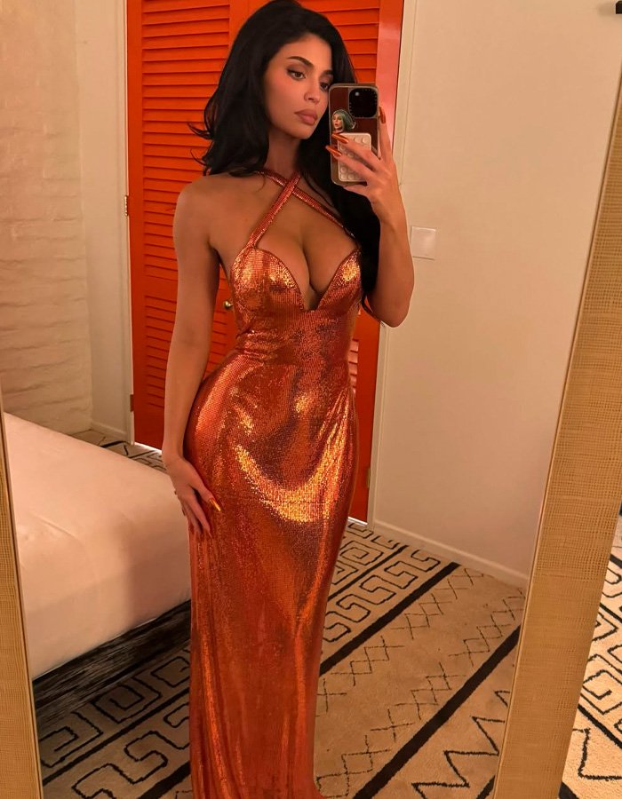 Kylie Jenner posing in a shimmering orange gown, taking a mirror selfie and sparking buzz with Timothée Chalamet outing.