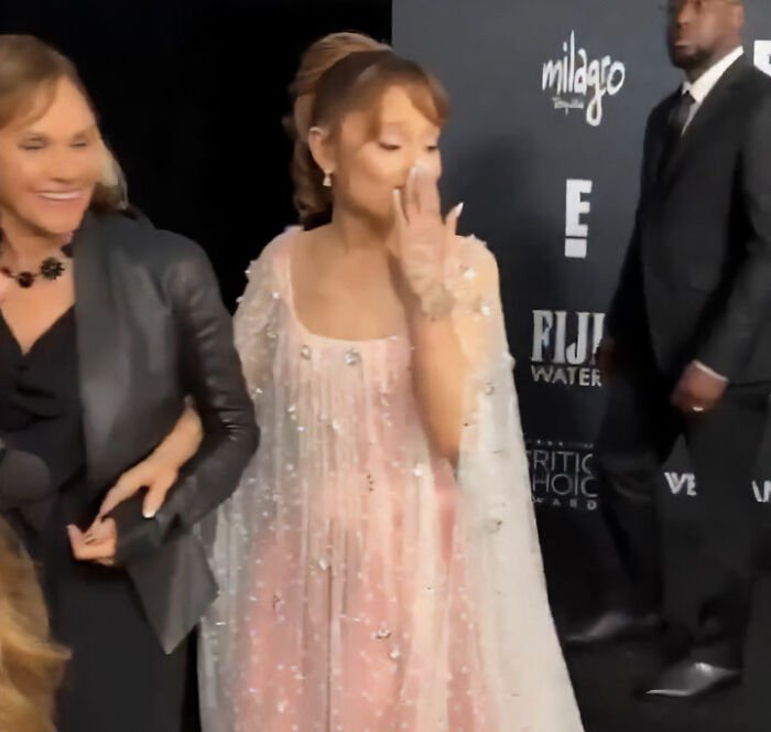 Leighton Meester laughing and covering face in a pink embellished dress at an event, amid Ariana Grande roasting buzz.