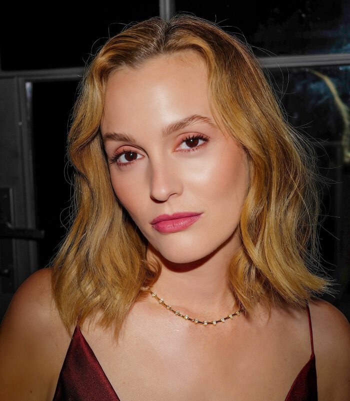 Woman with blonde hair wearing a gold necklace and burgundy top, related to Ariana Grande brutal roast after Leighton Meester mock.