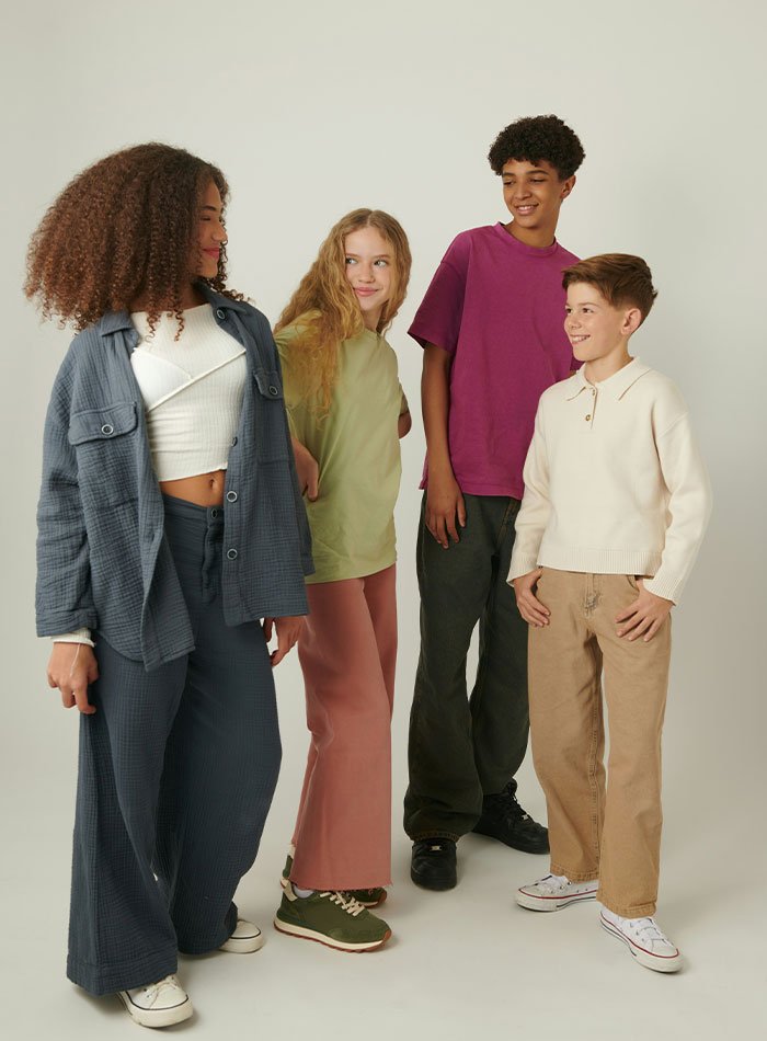 Four diverse teenagers smiling and chatting, illustrating overused slang words and phrases to be banished in 2026.