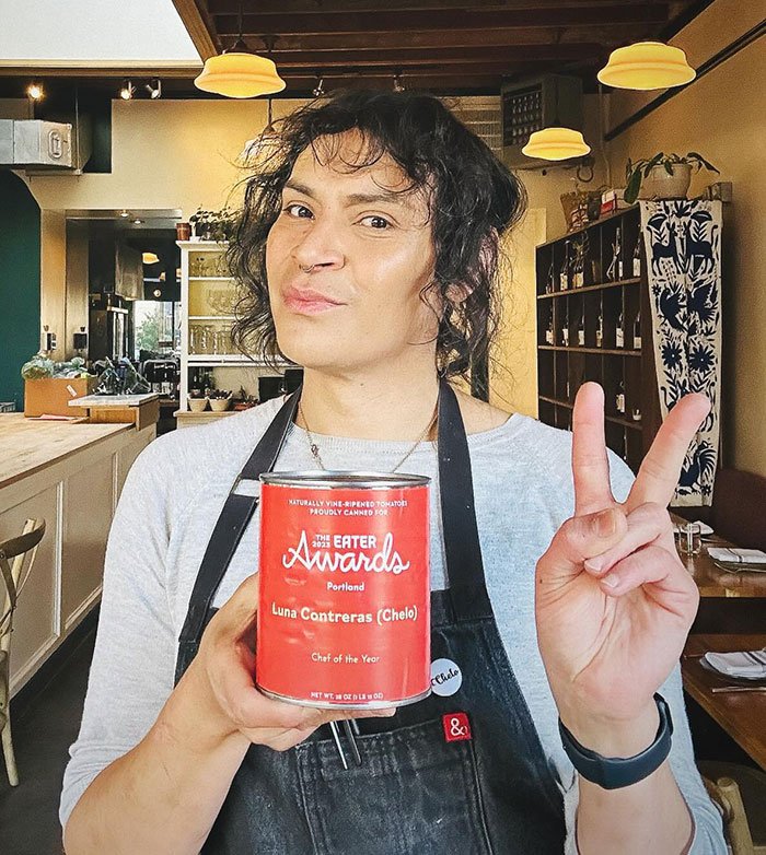 Person holding Chef of the Year award in a restaurant setting, related to trans chef controversy in media coverage.