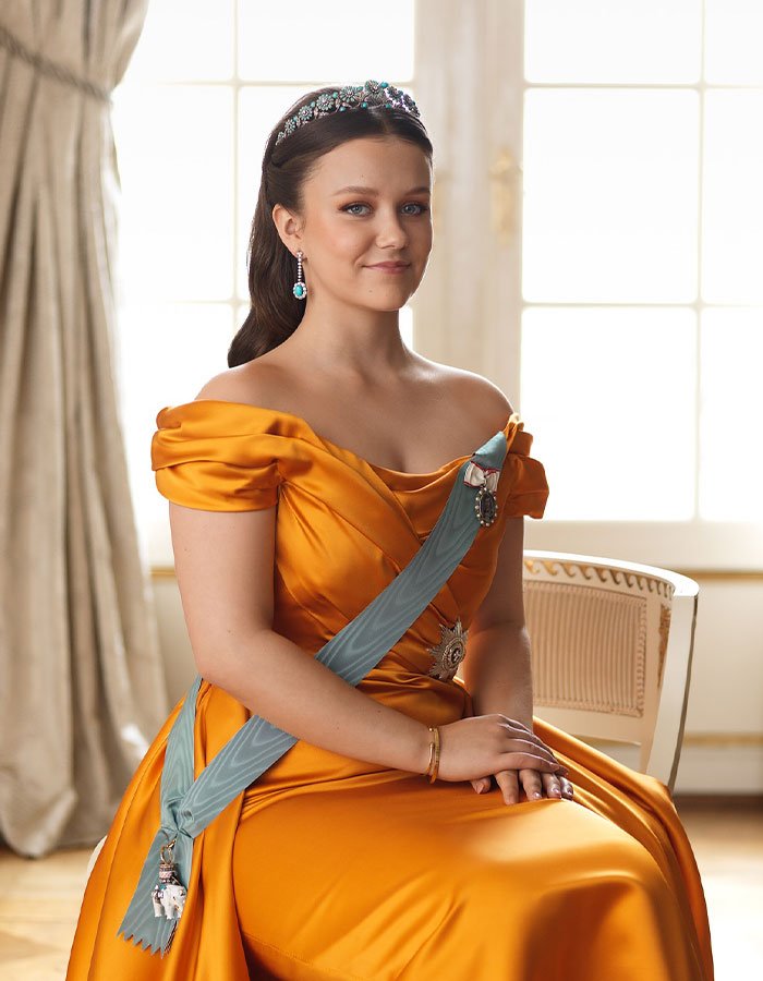 Princess Isabella wearing an orange royal gown and tiara, symbolizing monarchy and royal heritage in Greenland discussion.