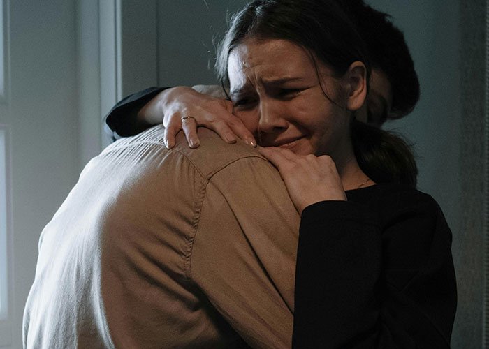 Woman demanding friend to kick husband out of romantic getaway, emotional and upset while hugging someone.