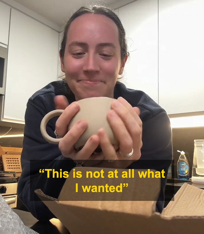 Woman holding a mug gift from fiancé, sparking huge relationship debate online with mixed emotions visible.
