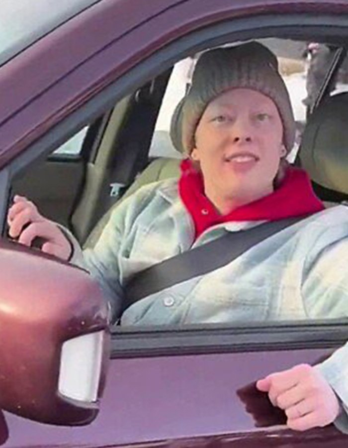 Person wearing a beanie and jacket sitting in a car, related to Renee Good’s wife breaking silence on fatal ICE incident.