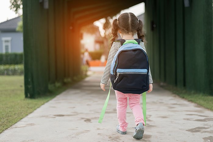Young girl with backpack walking outside, representing a 5-year-old niece related to skirt stealing incident.