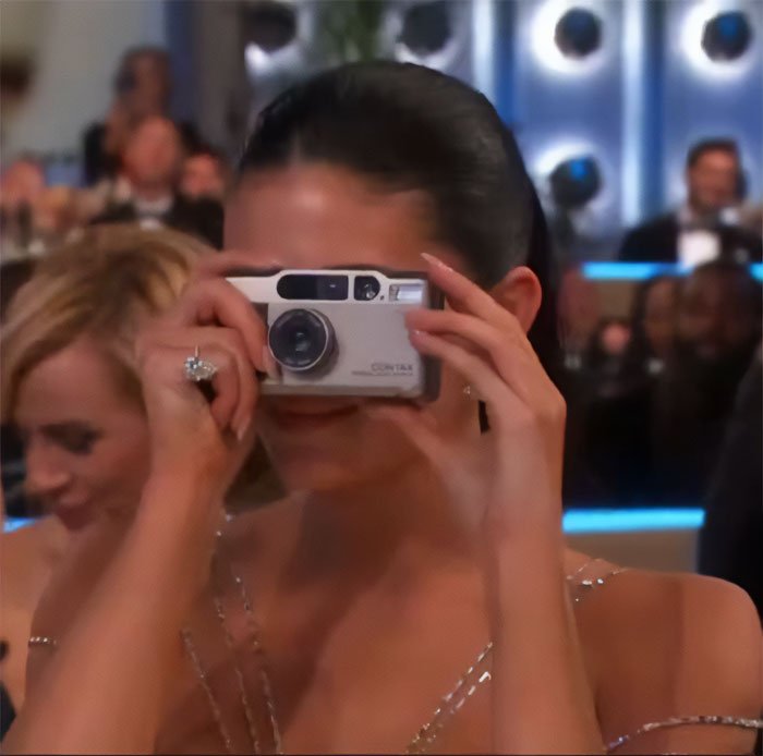 Celebrity at Golden Globes using a camera, highlighting after Timothée Chalamet snubs Kylie Jenner event moments.