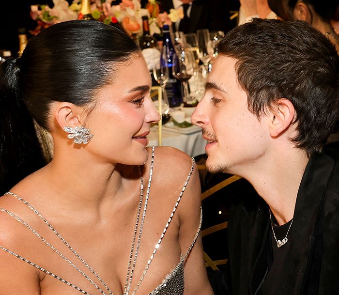 Kylie Jenner and Timothée Chalamet sharing a close moment at an event, hinting at a lip reader revealing a fight.