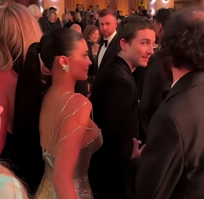 Timothée Chalamet and Kylie Jenner captured in a crowded Golden Globes event moment.