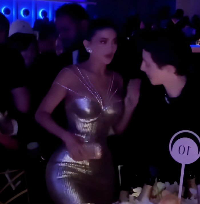 Timothée Chalamet and Kylie Jenner talking intensely at a crowded event, hinting at a lip reader's vicious fight reveal.
