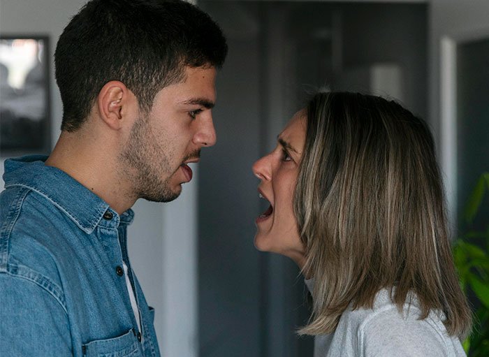 Couple arguing intensely indoors, representing conflict about open marriage and reconnecting with an ex partner.