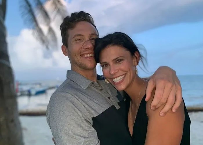 Couple smiling and embracing on a beach, related to ex FBI agent suggesting motive in Ohio dentist homicide case.