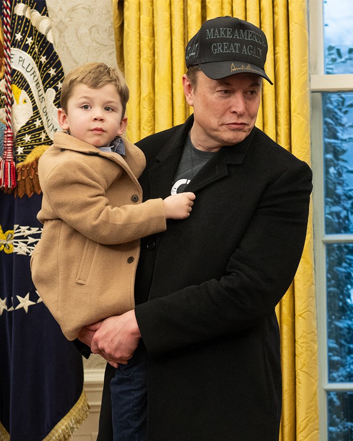 Man holding a child indoors, unrelated to Nicole Richie or her 18‑year‑old daughter’s new name reveal.