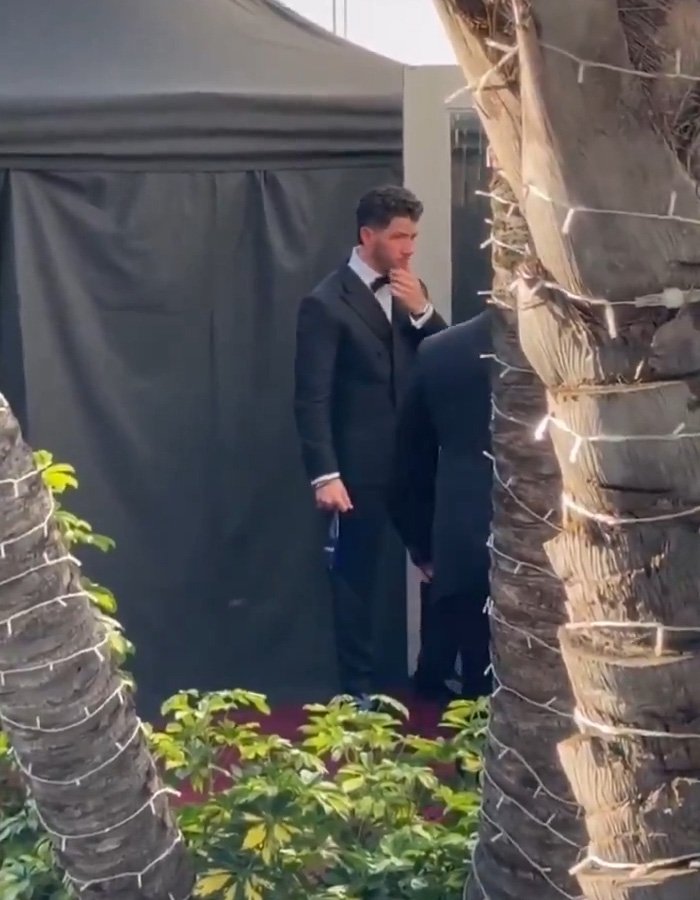 Nick Jonas in a black tuxedo walking out at Golden Globes 2026, captured in a viral video revealing the moment.
