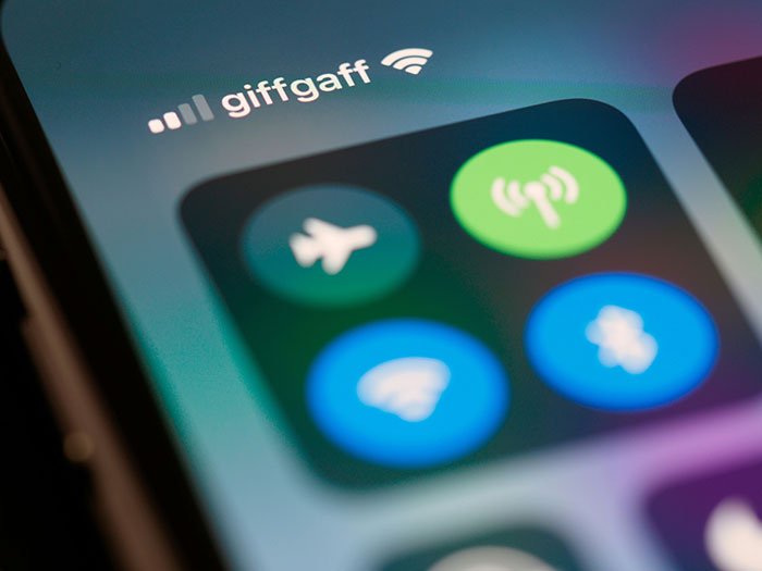 Close-up of smartphone screen showing WiFi hotspot and airplane mode icons related to fighter jets scrambled to escort flight.