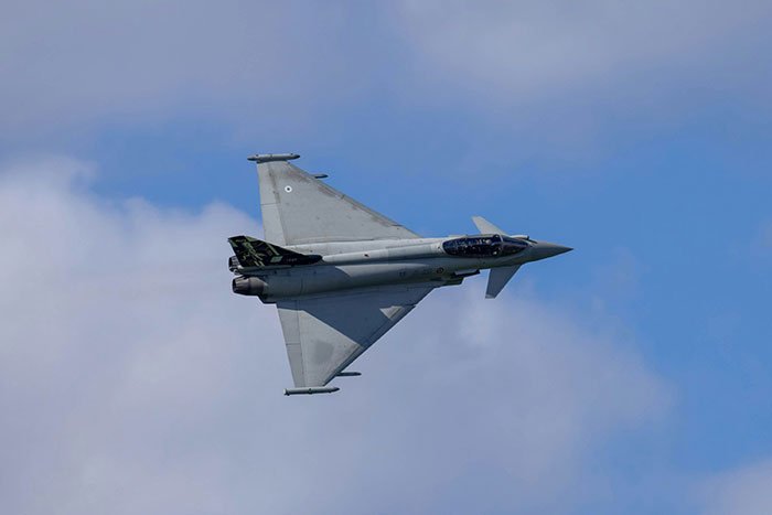 Fighter jet scrambling to escort flight due to passenger's provocative WiFi hotspot name in clear blue sky.