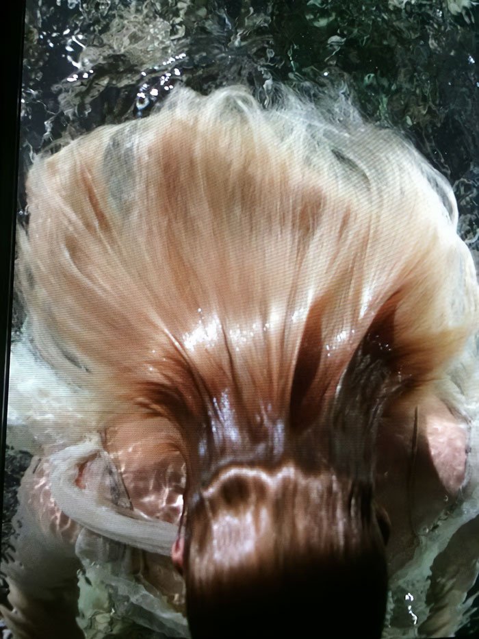 Underwater cover shoot featuring a woman with flowing hair submerged in water, capturing motion and light reflections.