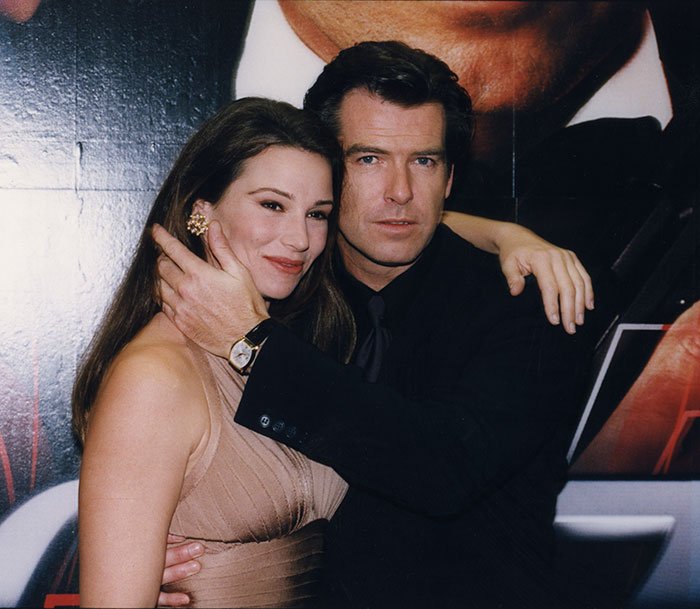 Pierce Brosnan and his wife posing at an event, highlighting reminder to avoid marriage and online trolls.
