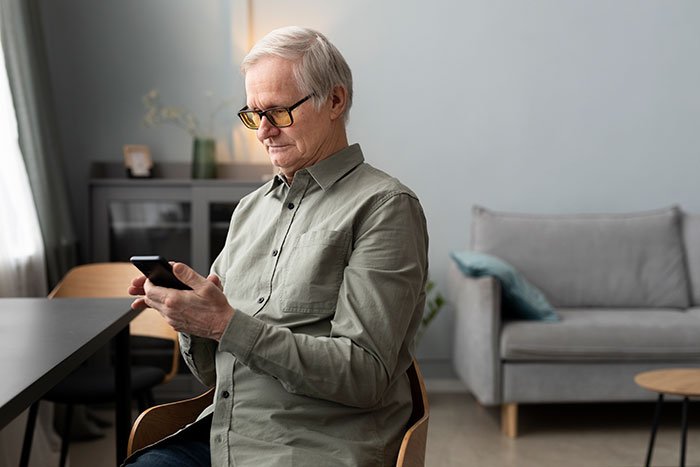Man upset using smartphone at home, concerned about tracking his car with an AirTag for safety reasons.