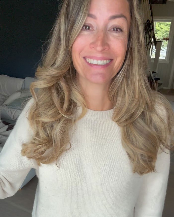 Woman with long blonde hair smiling indoors, related to David Beckham’s ex-assistant reacting to Brooklyn Beckham family rift.