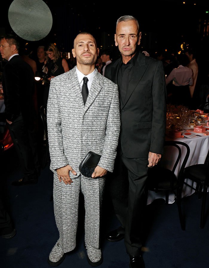 Two men dressed in formal attire at a wedding event revealing new details of Victoria Beckham’s inappropriate dance.