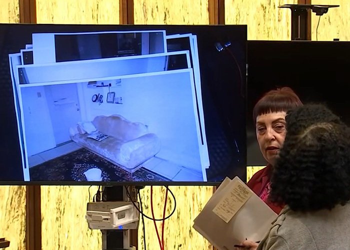 Two women discussing evidence files in front of a screen showing a room scene related to Alligator Alley disappearance case.