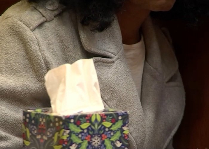 Person in gray coat holding a colorful tissue box, relating to five-year-old’s chilling last words before disappearance.