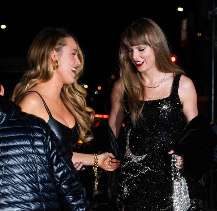 Taylor Swift smiling with a friend at night, highlighting Kim Kardashian's Taylor Swift comments sparking suspicion.
