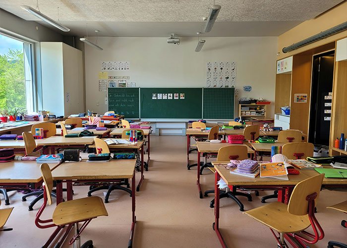 Classroom with empty desks and chairs, representing an assistant principal accused of Walmart theft stacking scheme.