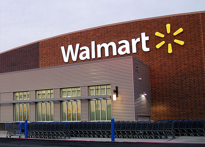 Walmart storefront at dusk with shopping carts lined up outside, related to assistant principal theft scheme using stacking method.