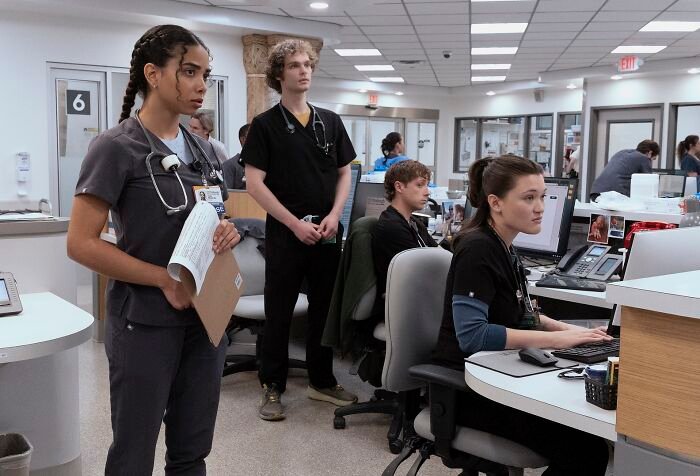 Hospital staff in scrubs at nurses station, depicting Pitt fans dragging new Season 2 addition amid potential romance.