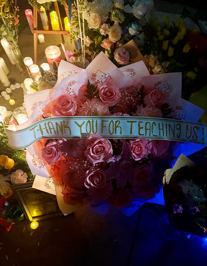 Memorial with flowers and candles honoring a teacher’s life after husband uncovers affair in diary discovery.