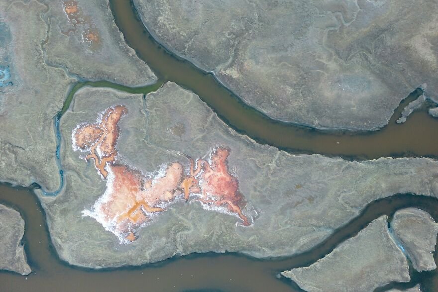 Aerial view of winding rivers and land patches representing Earth’s natural features in a planet for sale concept.