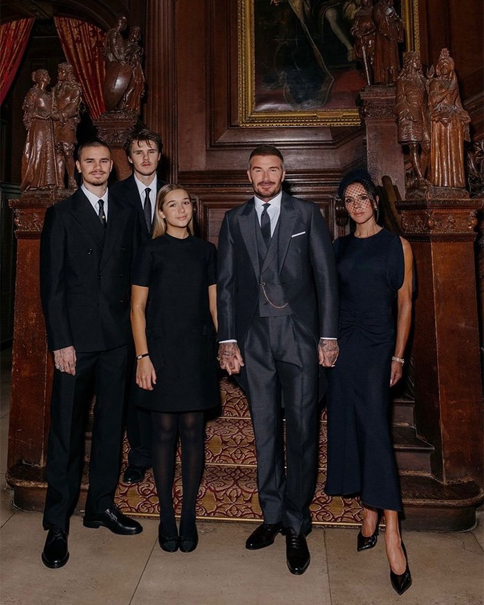 David Beckham with family members dressed formally, posing in an ornate room amid ongoing family rift discussions.