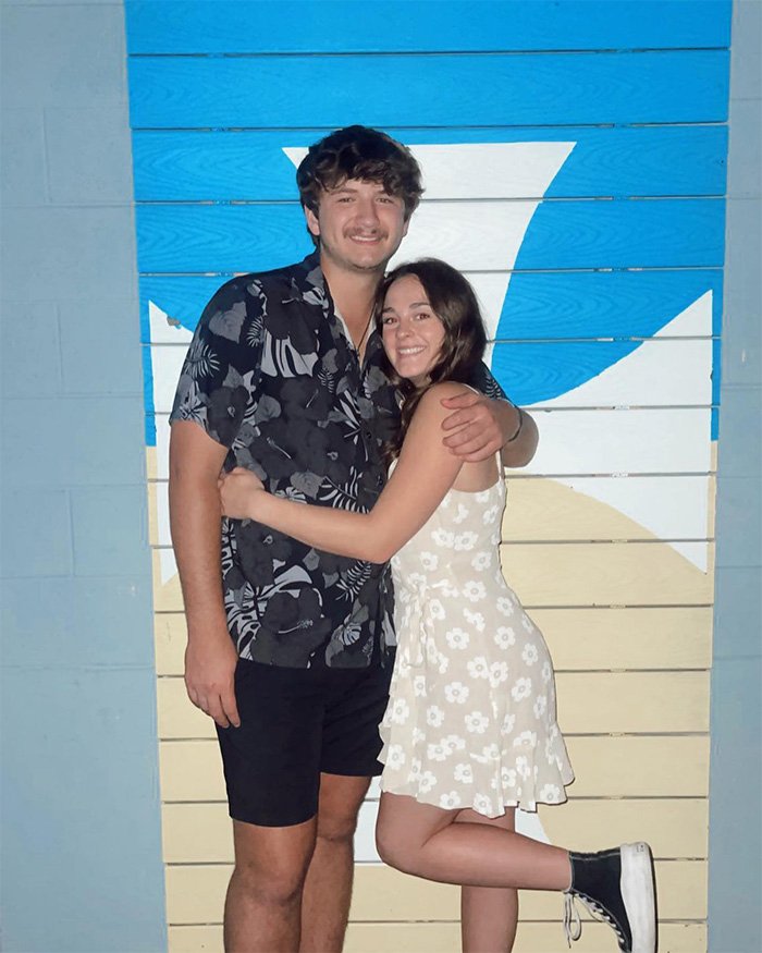 Young couple posing happily against a colorful wall, connected to disturbing new details in autopsy reports of victims.