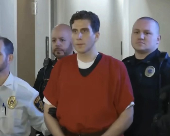 Bryan Kohberger escorted by officers in a courtroom, related to disturbing new details about victims in autopsy reports.