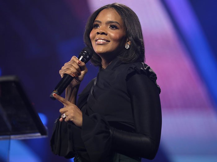 Erika Kirk holding microphone with a smile during a live event, amid backlash from leaked clip and explosive audio.