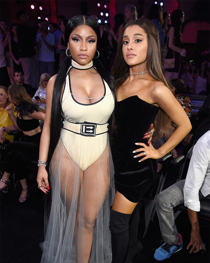 Nicki Minaj in sheer outfit and Ariana Grande in black dress posing at an event amid Ariana Grande snubs Nicki Minaj news.